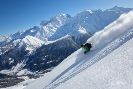 Skier skiing powder on steep slope with high mountain scenery - Snow-wise - Our complete guide to Megève, France - Megève for experts