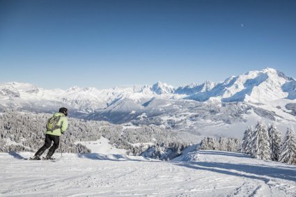 Skiier on intermediate slope with snow-covered mountain views - Snow-wise - Our complete guide to Megève, France - Megève for intermediates