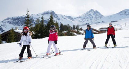 Children skiing on snow-covered piste in Courchevel, France - Snow-wise luxury ski holidays at February Half Term 2023