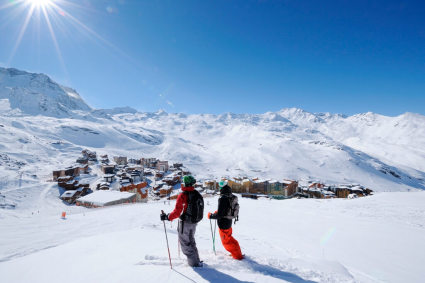 Skiers overlooking the snow-covered resort of Val Thorens in the French Alps